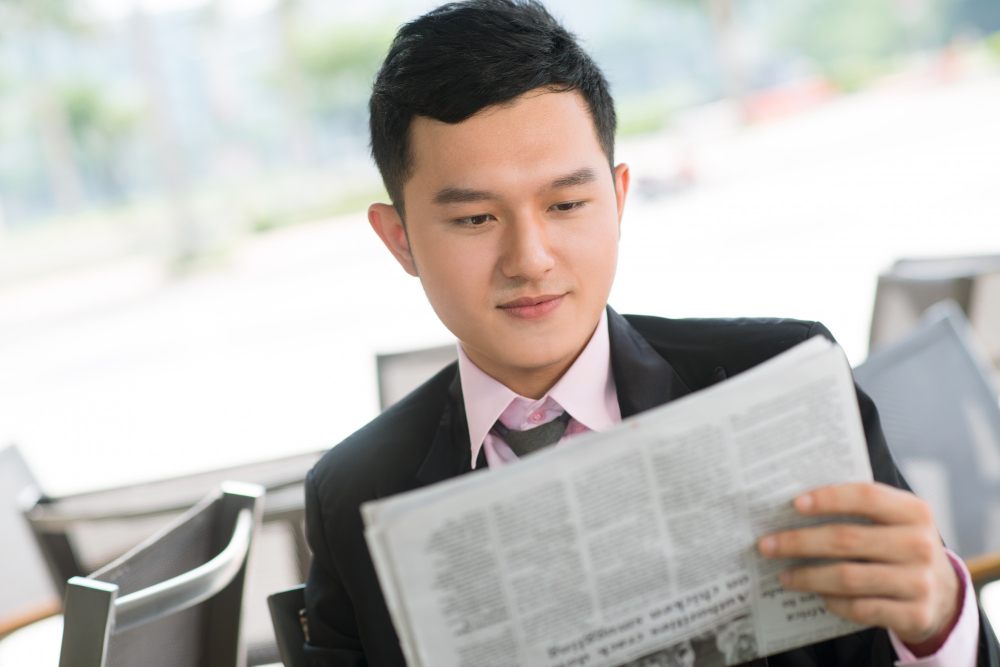 An Asian man reading press release